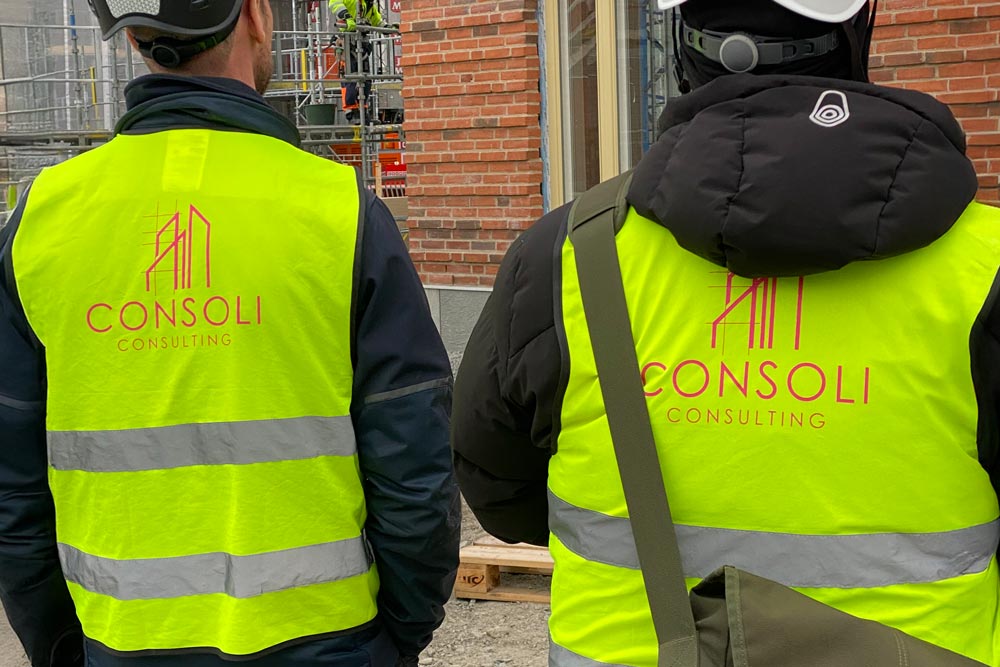 Konsulter har på sig västar med Consoli Consulting logga tryckt på deras ryggar